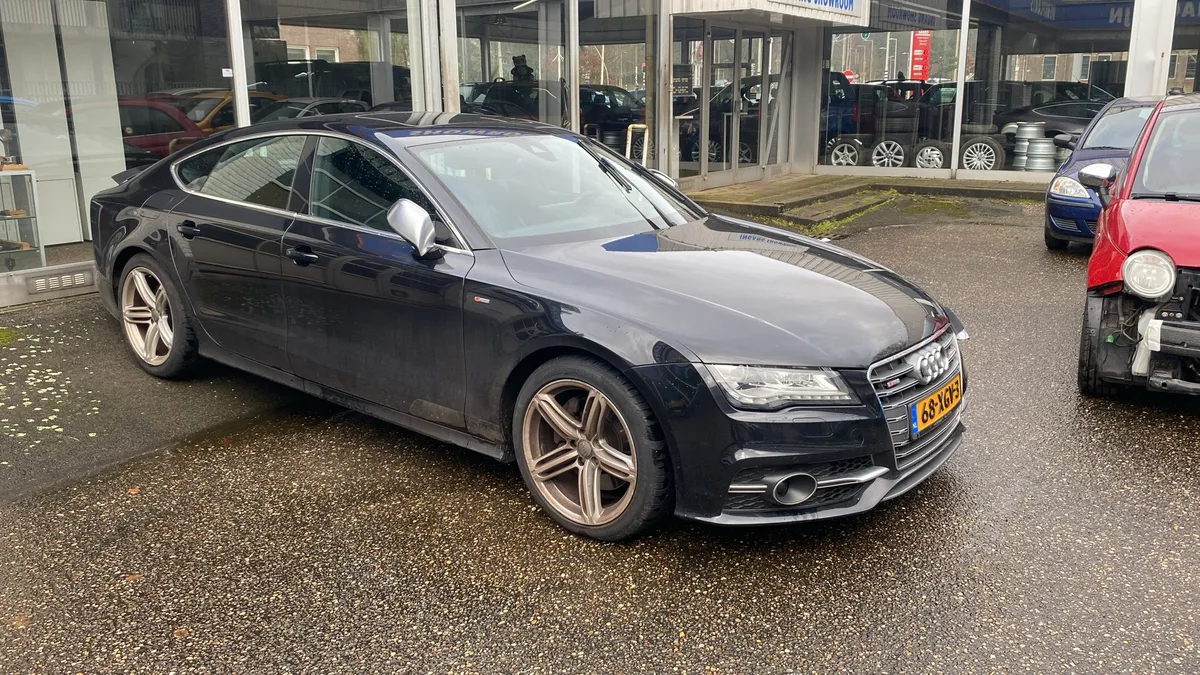 Donkere Audi A7 S-line vooraanzicht bij een autobedrijf