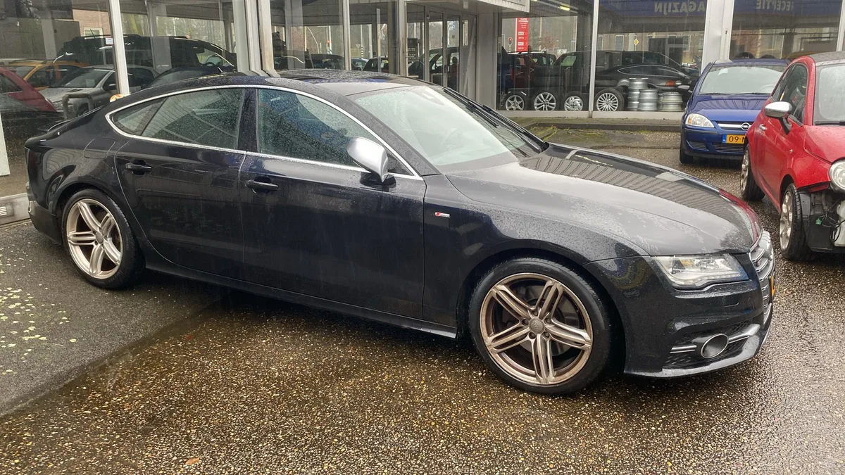 Donkere Audi A7 S-line zijaanzicht bij een dealer