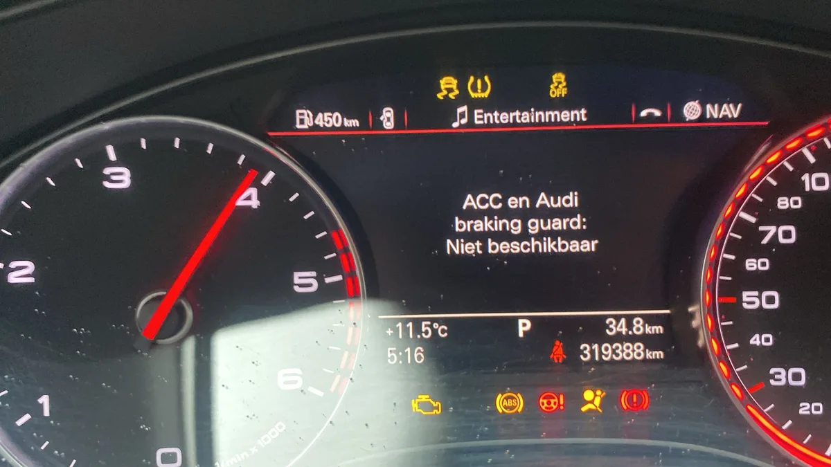 Audi dashboard met 319.388 kilometer en waarschuwingslampjes