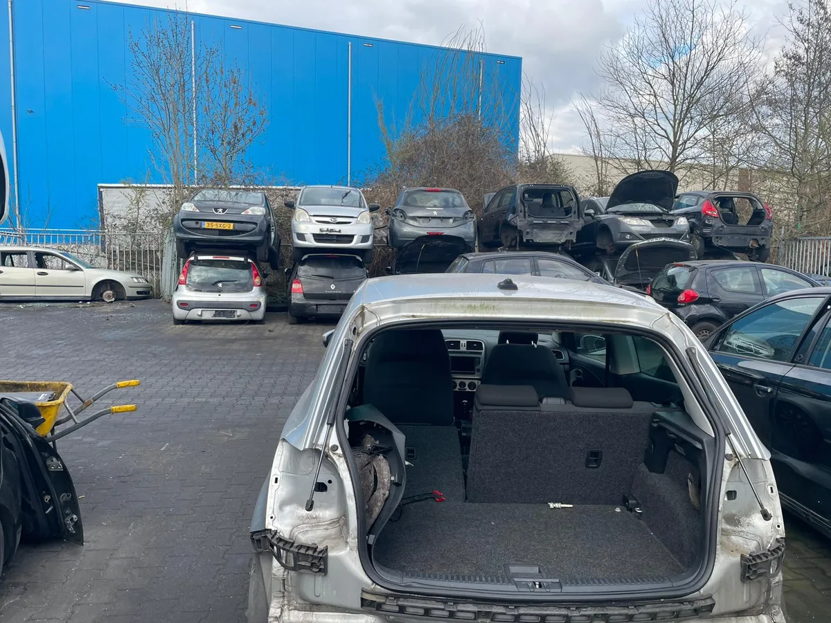 Overzicht van een autosloperij met gestripte auto's klaar voor recycling
