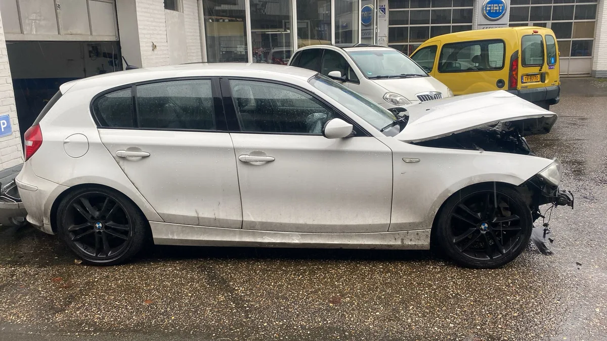 Witte BMW 1-Serie met ingedrukte voorkant na aanrijding