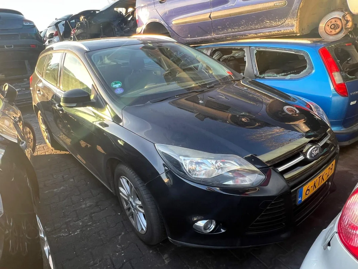 Zwarte Ford Focus op een autosloperij met Nederlands kenteken