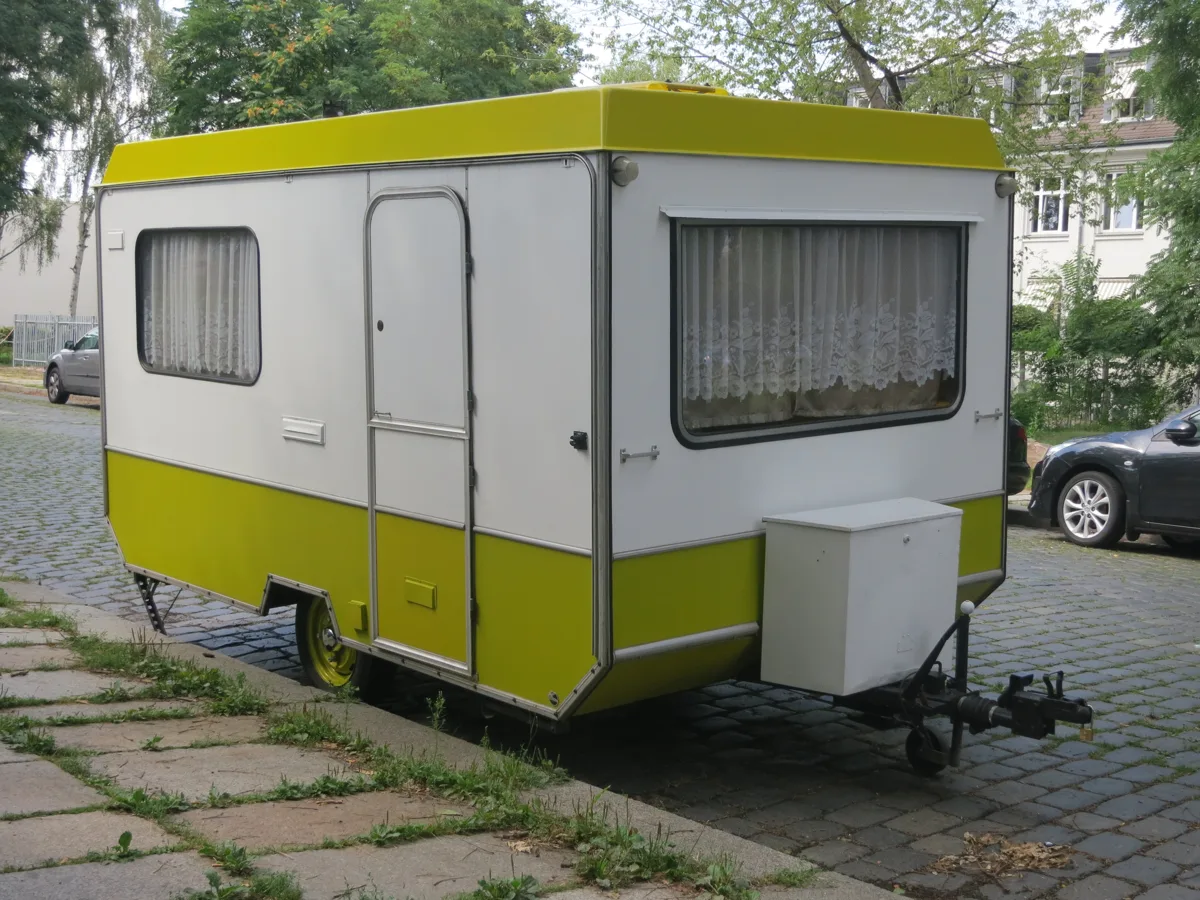 Oude geel-witte toercaravan uit de jaren zeventig