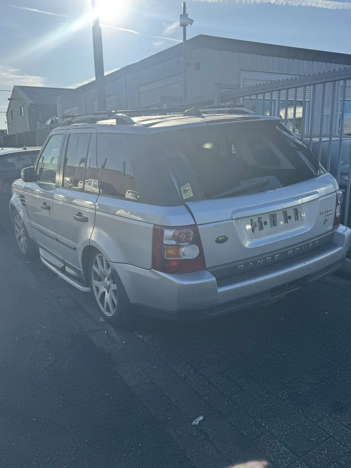 Zilveren Range Rover Sport achterkant op een autosloperij