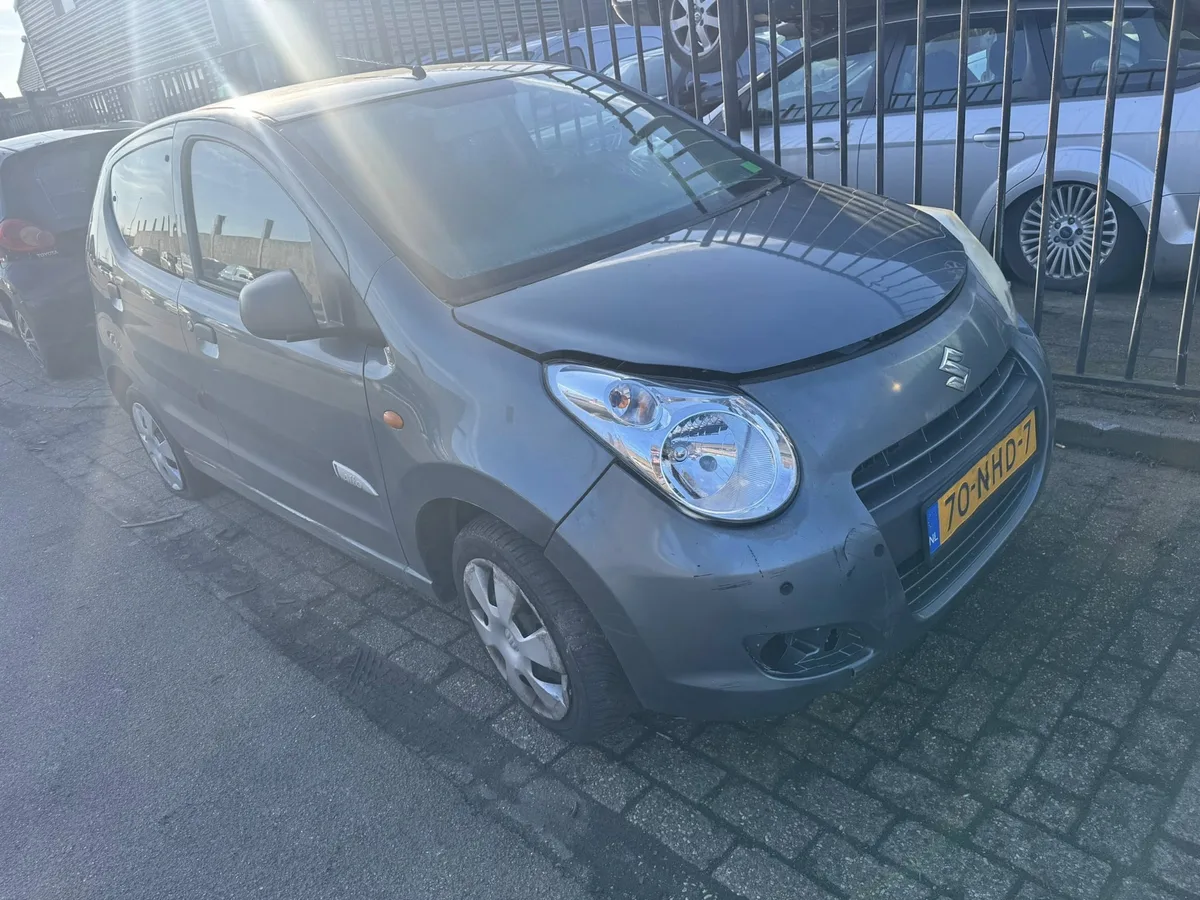 Grijze Suzuki sloopauto op een autosloperij