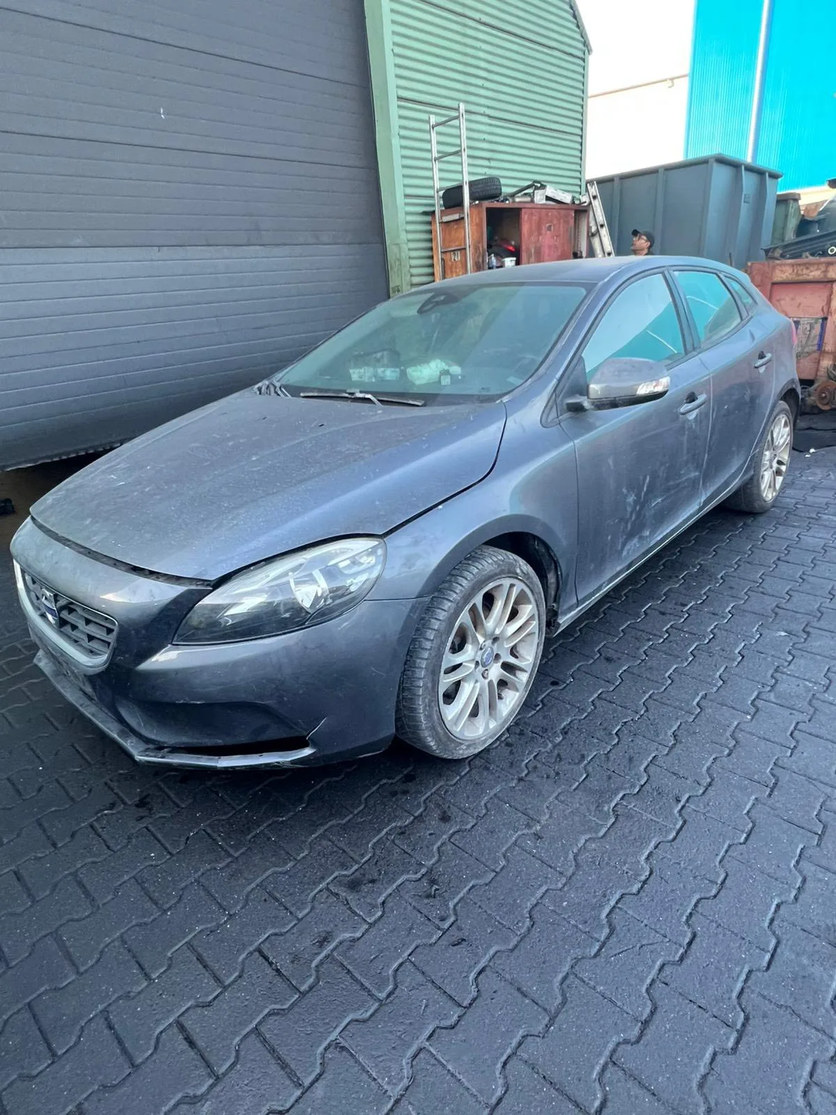Grijze Volvo V40 met lichte schade op een sloperij